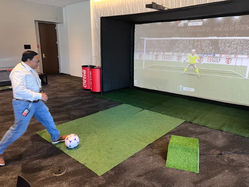 World Cup football simulator rental with large screen setup for trade show booth engagement