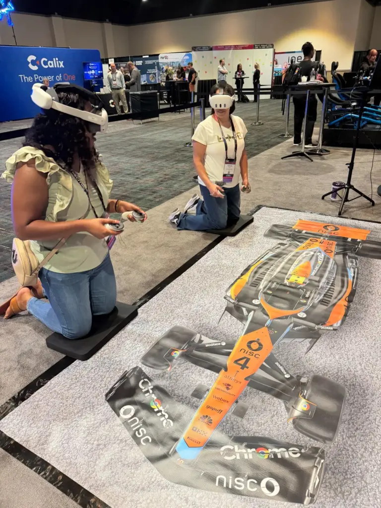 Two guests wearing VR headsets playing the pit stop game on a branded pit lane mat