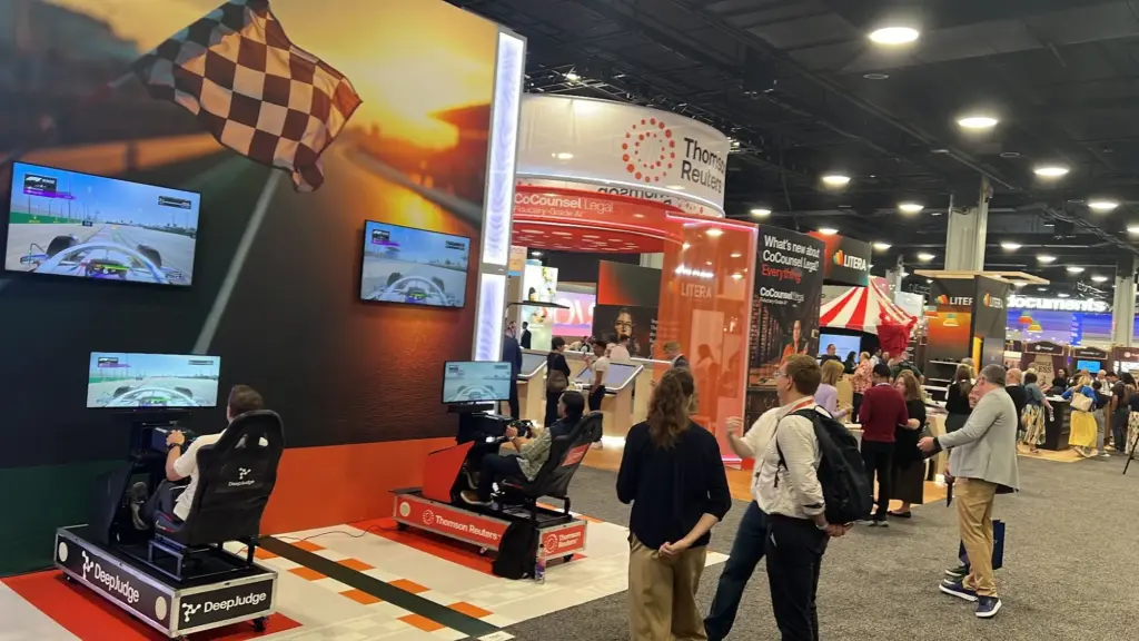 Guests racing head-to-head on branded racing simulators at a trade show booth