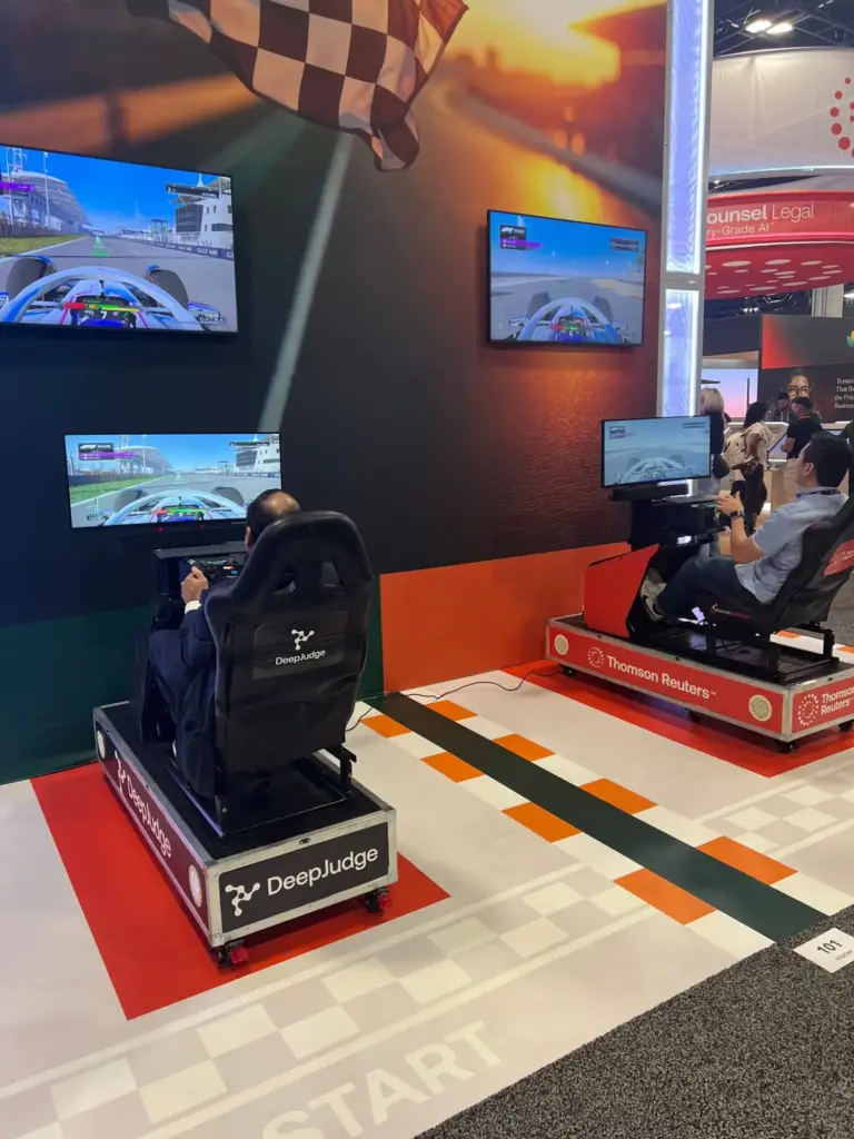 Attendees driving Thomson Reuters and DeepJudge branded racing simulators at ILTACON in Nashville