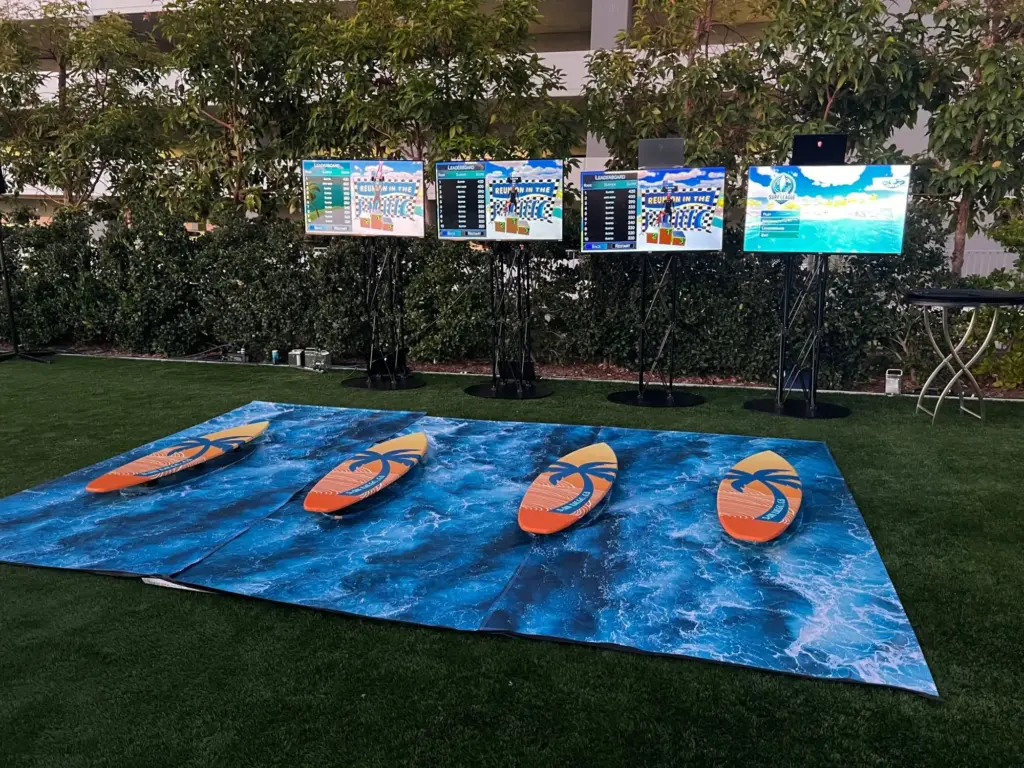 Four surf simulators with live leaderboard screens on an outdoor lawn at Gaylord Pacific Resort, San Diego