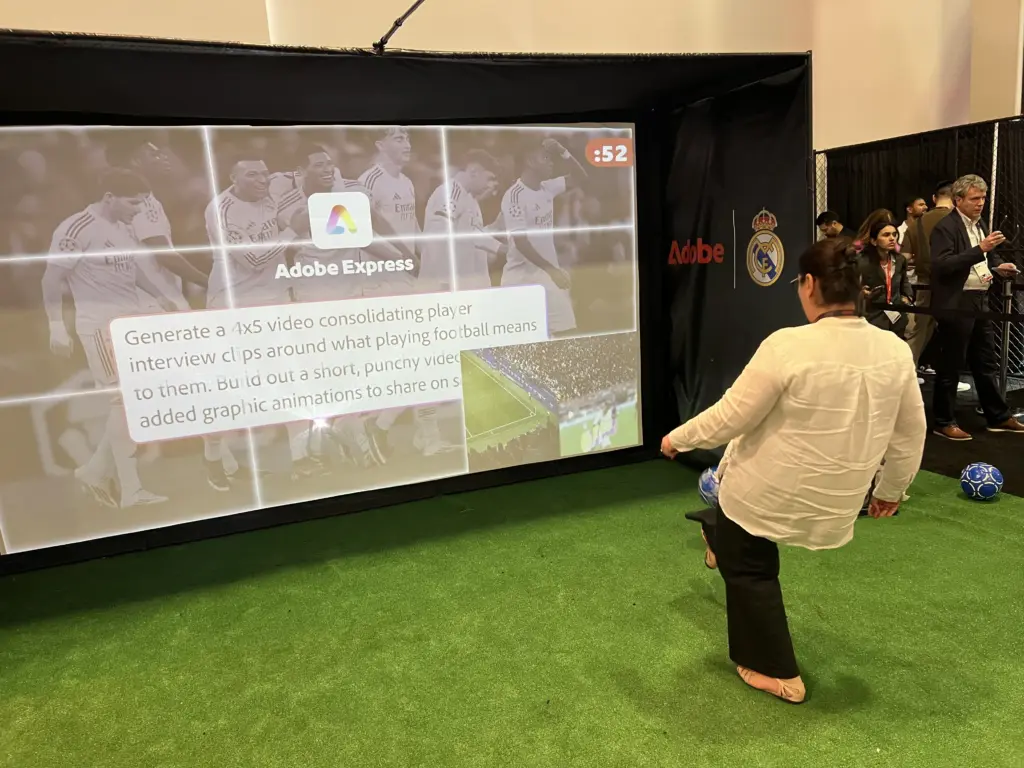 Attendee kicking at the soccer image reveal game showing an Adobe Express AI prompt over Real Madrid players at Adobe Summit 2026