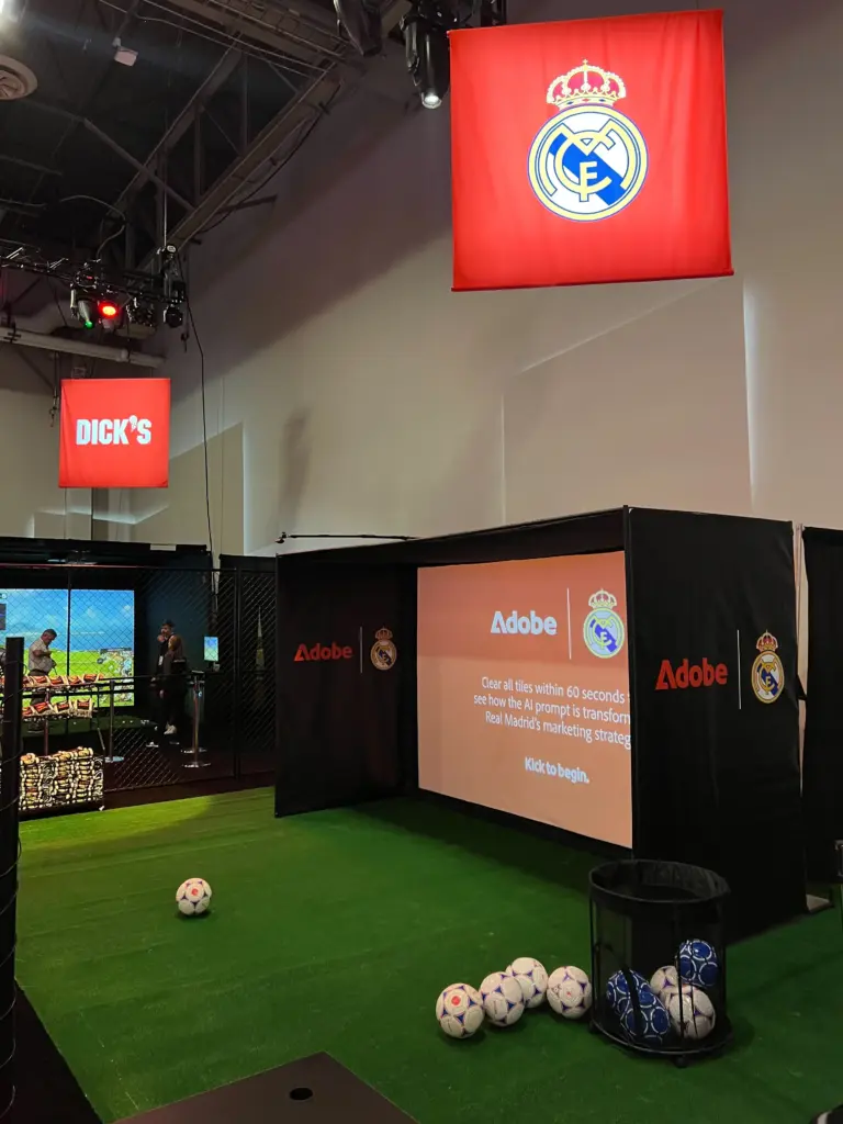 Adobe and Real Madrid branded digital shootout booth with soccer balls ready on the turf at Adobe Summit 2026, Venetian Expo, Las Vegas