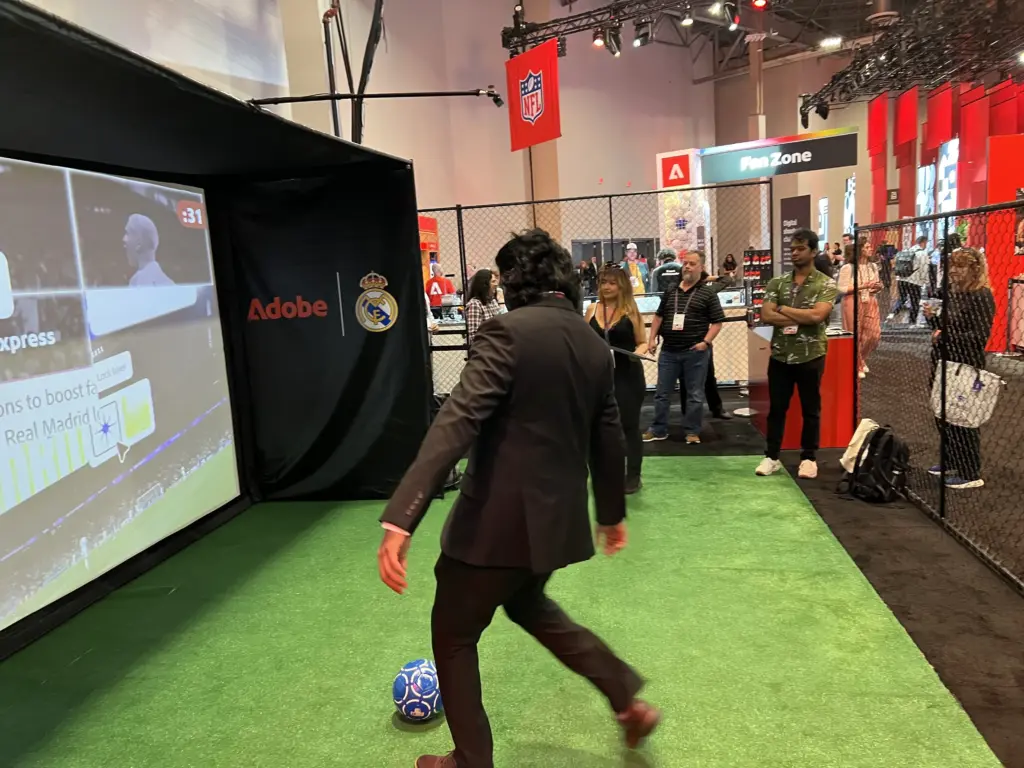 Attendee in a suit lining up a shot at the Adobe and Real Madrid digital shootout in the Adobe Summit Fan Zone, Venetian Expo, Las Vegas