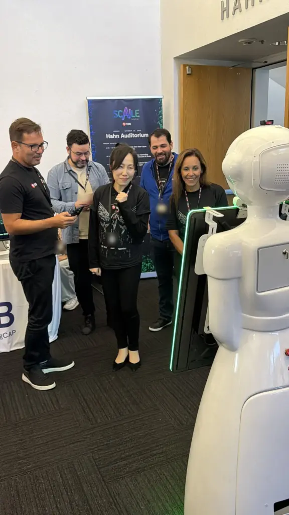Conference attendees smiling at the AI photo booth robot as their AI portrait is created