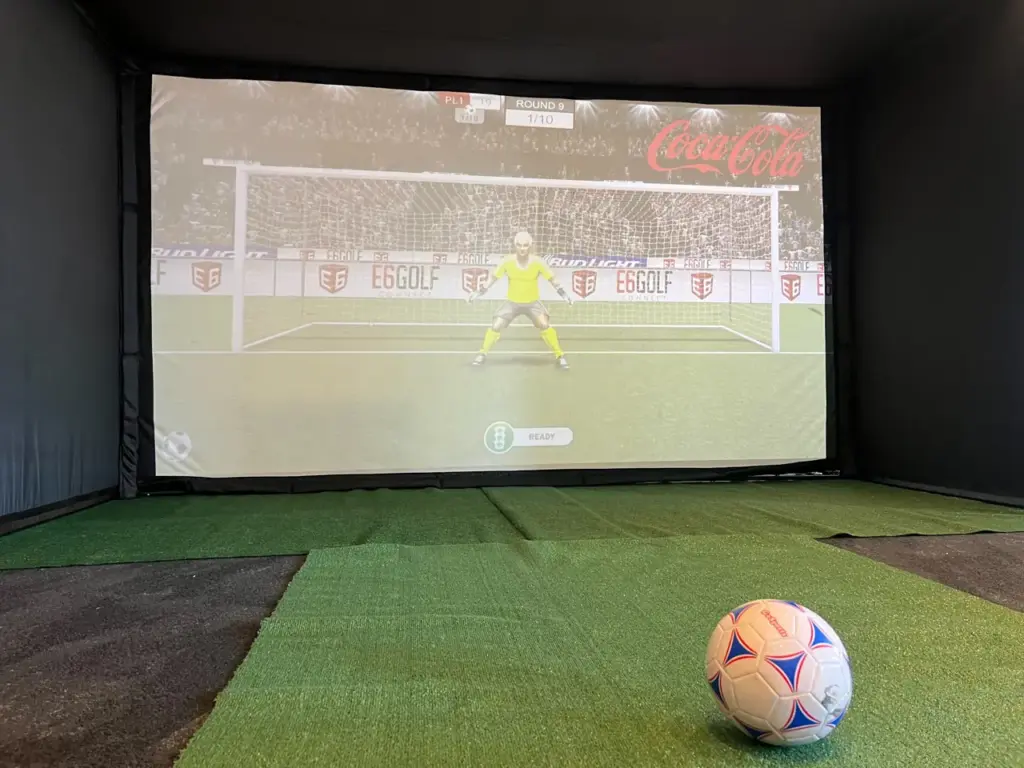 Soccer simulator with Coca-Cola branding on the goal screen at Coca-Cola headquarters in Atlanta