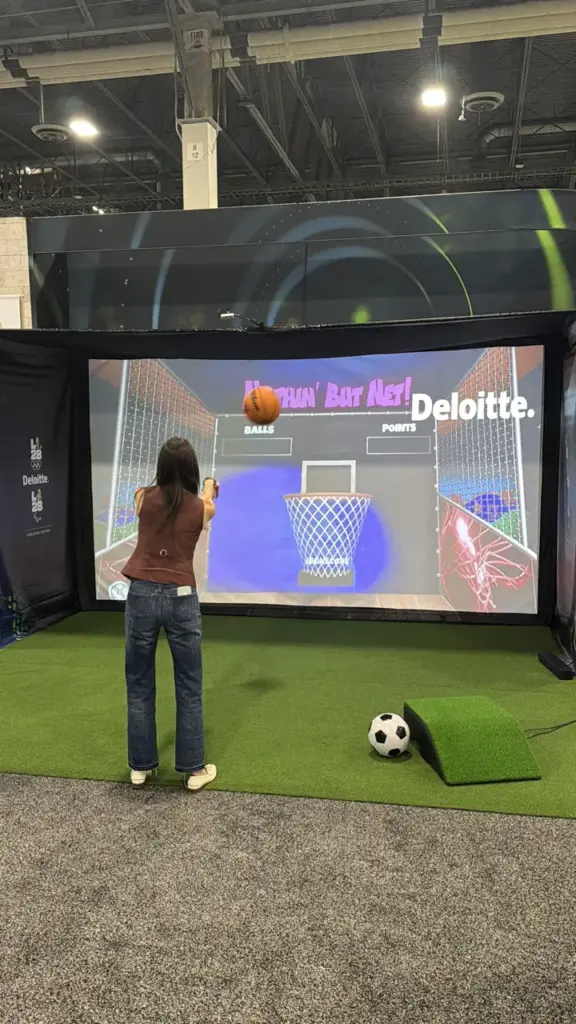 Attendee shooting hoops on a Deloitte branded basketball sport simulator at the Venetian Expo in Las Vegas