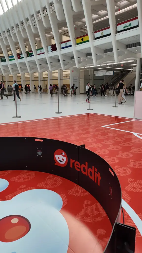Reddit logo on the wall of the soccer reaction ring under the Oculus ceiling ribs in New York