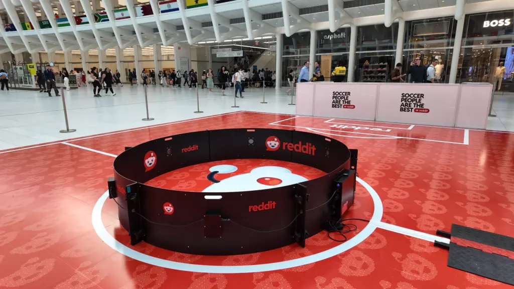 Reddit-branded soccer reaction ring on a red pitch inside the Oculus transit hall at the World Trade Center, New York