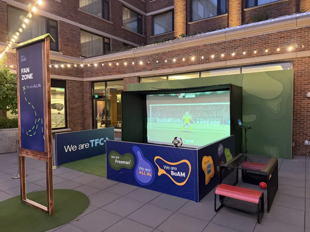 Soccer simulator with branded side walls and two seated soccer games in a Fan Zone on the outdoor terrace of Hyatt Regency Lake Washington, Renton