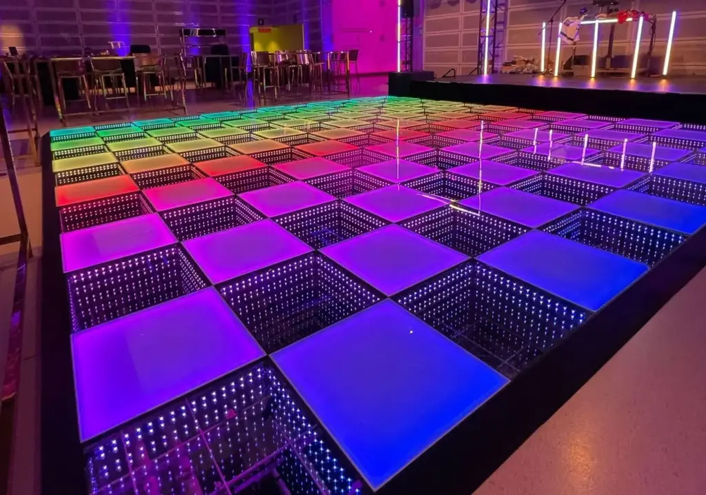 LED dance floor rental glowing pink, blue and purple in an event ballroom