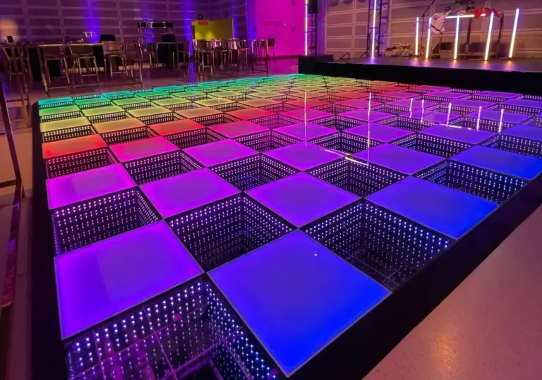 LED dance floor rental glowing pink, blue and purple in an event ballroom