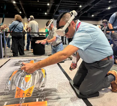 Guest in a VR headset changing a tire in the Pit Stop Challenge VR game at a trade show