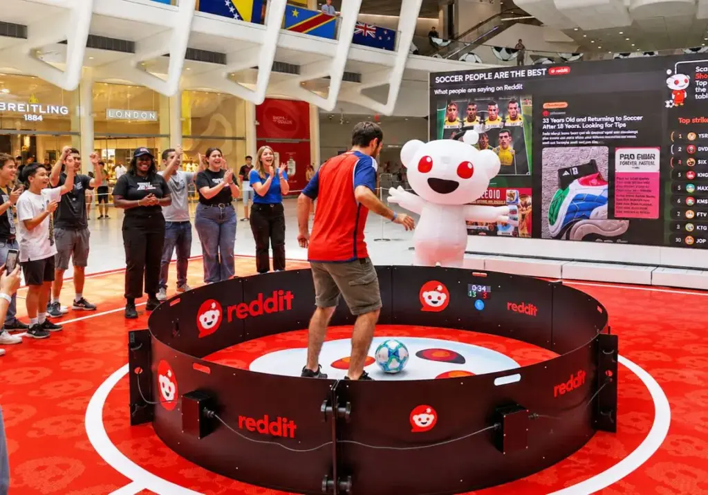 Crowd watching a player inside a soccer reaction ring rental at a branded trade show activation