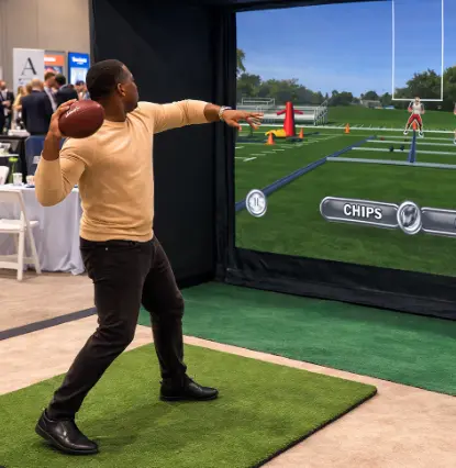 Guest throwing a football at the screen of a football simulator rental